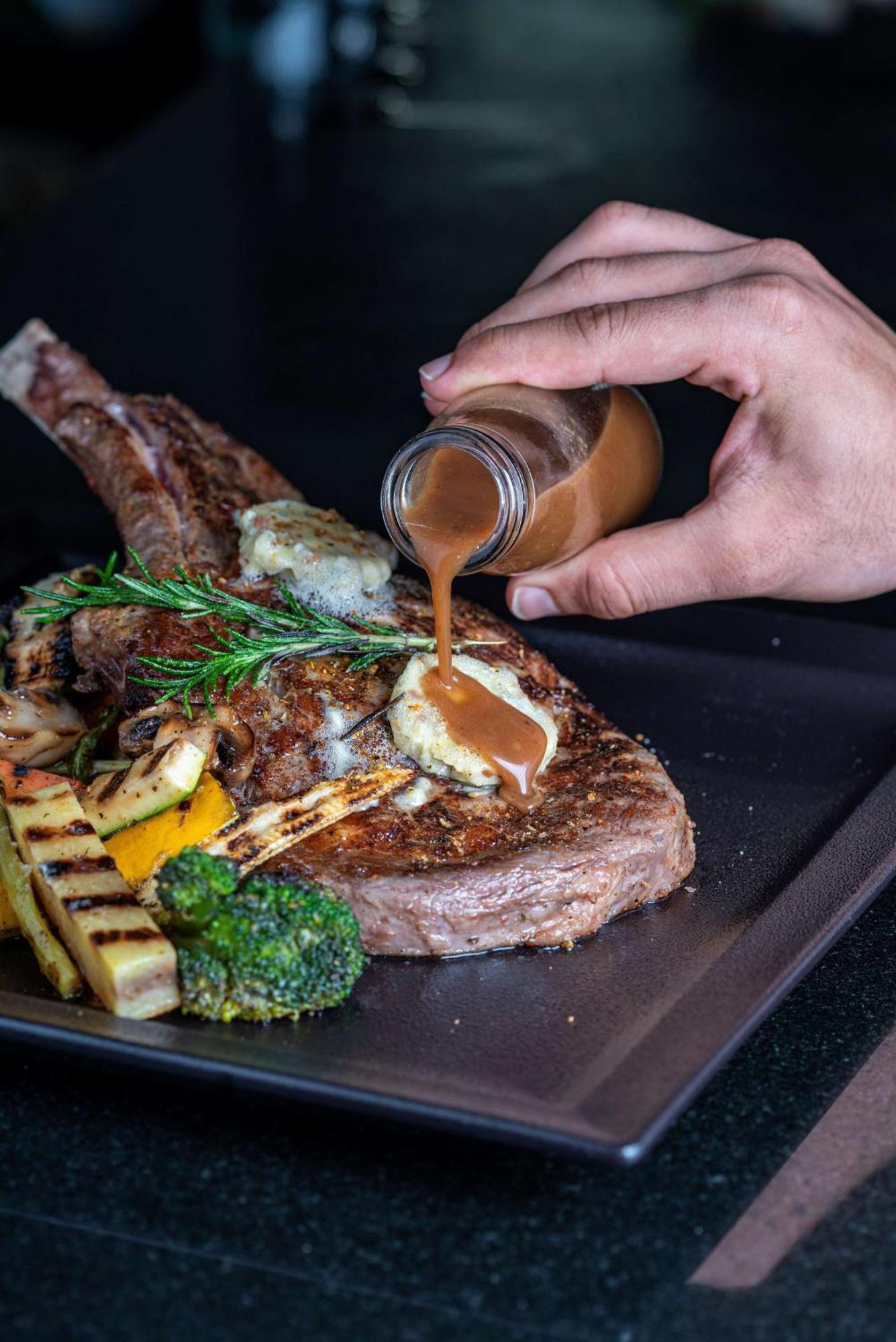 Radisson Blu Hotel & Resort, Szohár Kültér fotó A steak being drizzled with a sauce